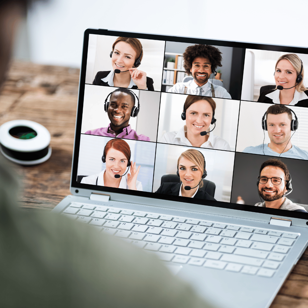 Smiling employees on a laptop screen during an employee coaching session