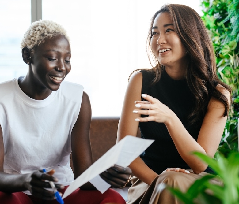 Two women discuss employee performance and how Sanctus Coaching and Mentoring supports it