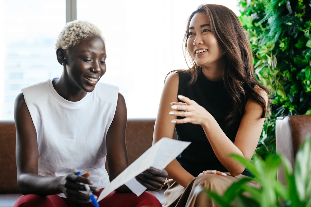 Two women discuss employee performance and how Sanctus Coaching and Mentoring supports it